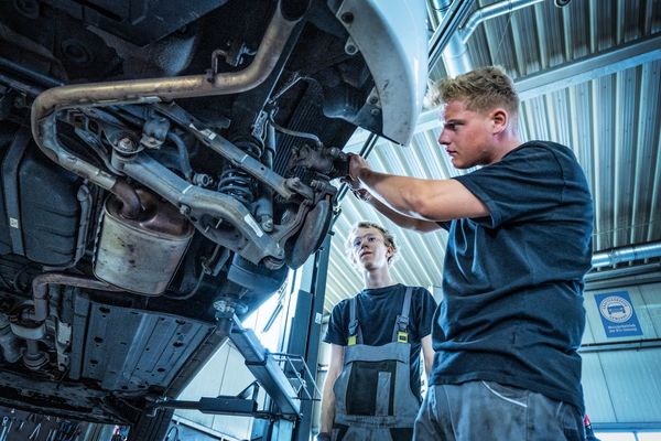 kfz-Mechatroniker führt Bremsencheck in der Werkstatt durch